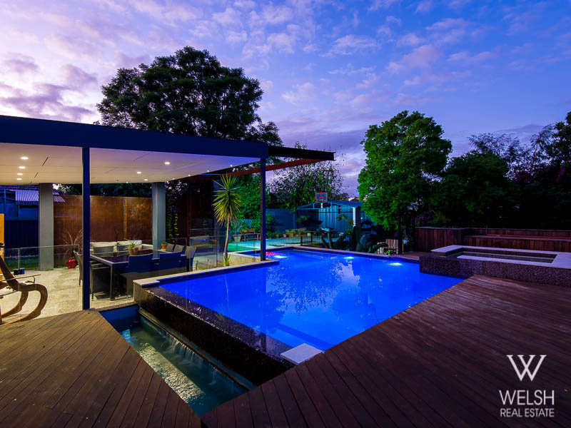 Diseño de piscina elevada minimalista de tamaño medio en forma de L en patio trasero con entablado