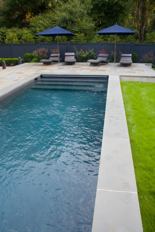 Ejemplo de piscina alargada clásica renovada de tamaño medio rectangular en patio trasero con granito descompuesto