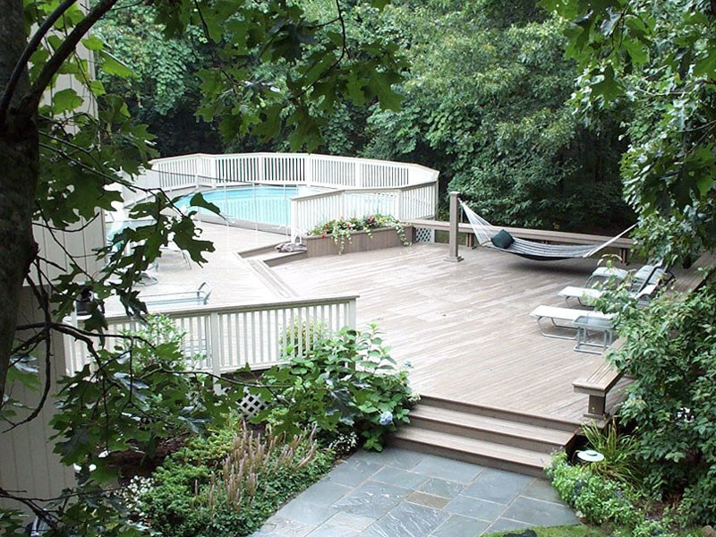 Idée de décoration pour une piscine hors-sol et arrière tradition de taille moyenne et ronde avec une terrasse en bois.