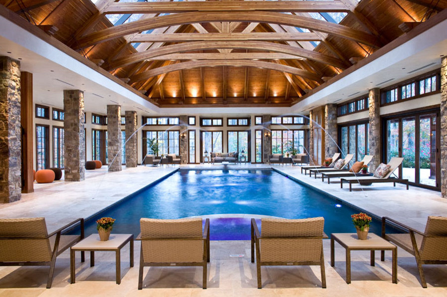 Cette photo montre une très grande piscine intérieure chic rectangle avec un bain bouillonnant et du carrelage.