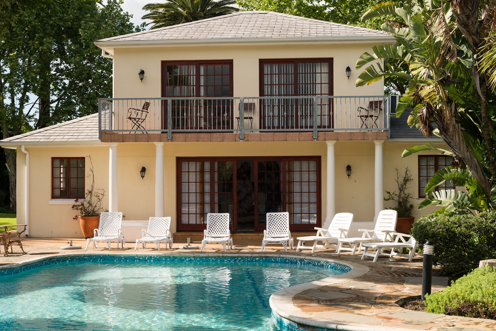 Photo of a large classic back custom shaped lengths swimming pool in Dortmund with natural stone paving.