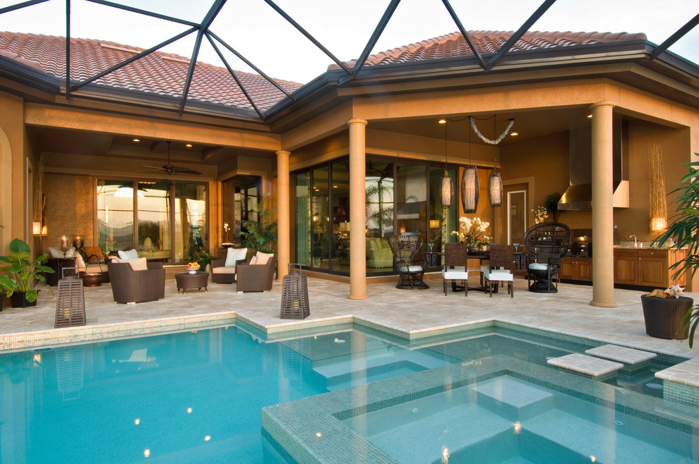 Esempio di una grande piscina monocorsia classica personalizzata dietro casa con una vasca idromassaggio e pavimentazioni in pietra naturale