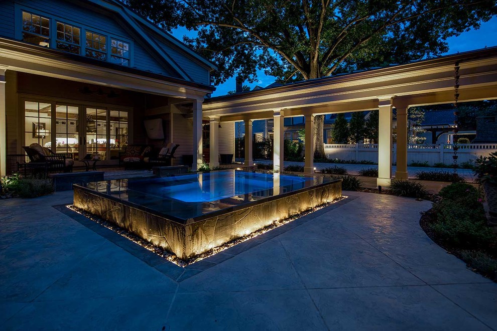 Esempio di una piscina a sfioro infinito design personalizzata di medie dimensioni e dietro casa con una vasca idromassaggio e cemento stampato