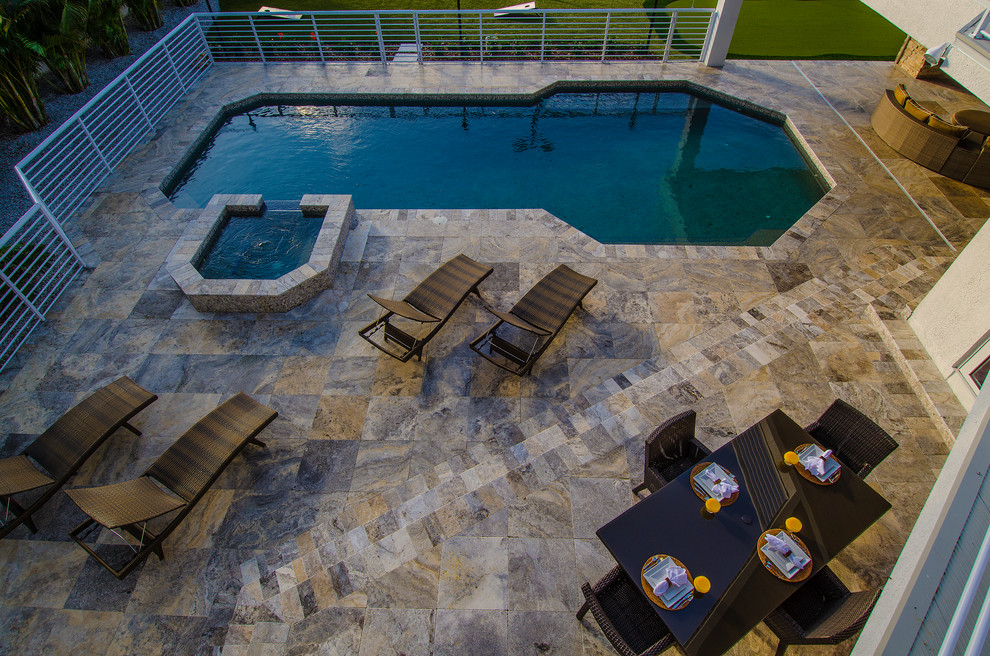 Example of a large trendy backyard stone and custom-shaped hot tub design in Tampa