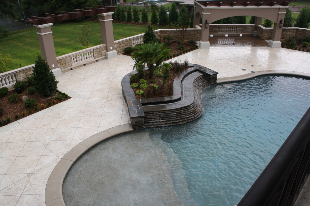 Idee per una grande piscina naturale stile marino personalizzata dietro casa con cemento stampato e una vasca idromassaggio