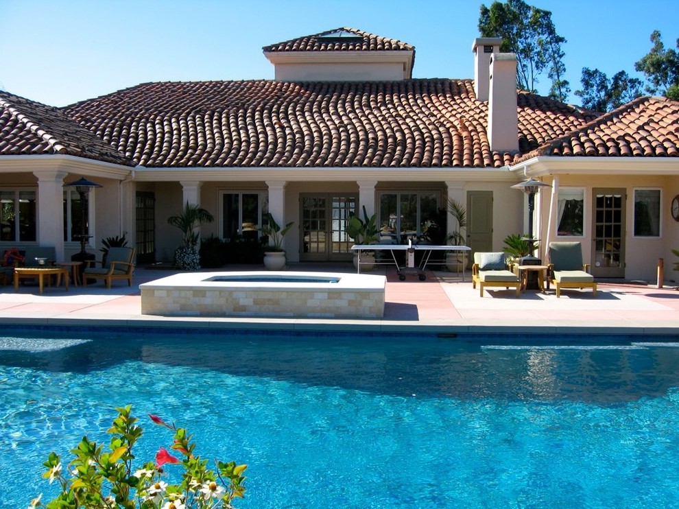 Idee per un'ampia piscina contemporanea rettangolare dietro casa con una vasca idromassaggio e lastre di cemento