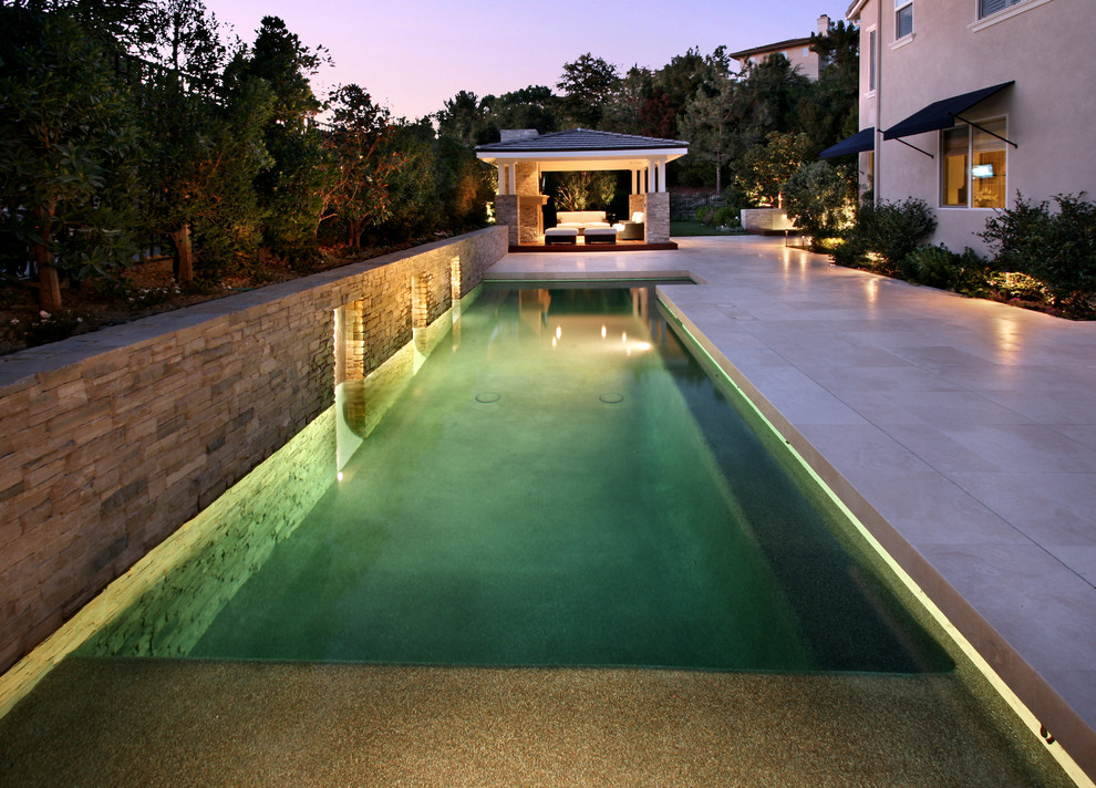 Ejemplo de piscina contemporánea de tamaño medio rectangular en patio trasero con suelo de baldosas