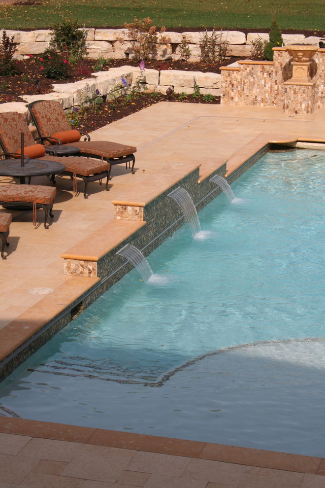 Inspiration for a large mediterranean back rectangular swimming pool in Other with a water feature and natural stone paving.