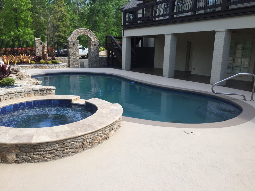 Diseño de piscinas y jacuzzis alargados modernos extra grandes tipo riñón en patio trasero con entablado