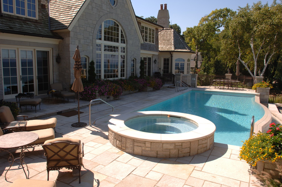 Example of a backyard stone and custom-shaped pool design in Other