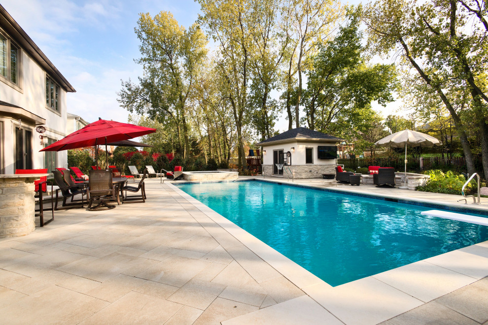 Imagen de piscina con fuente alargada actual extra grande rectangular en patio trasero con adoquines de piedra natural