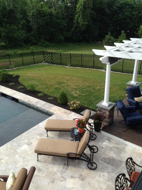 Photo of a large traditional back rectangular swimming pool in Philadelphia with natural stone paving.