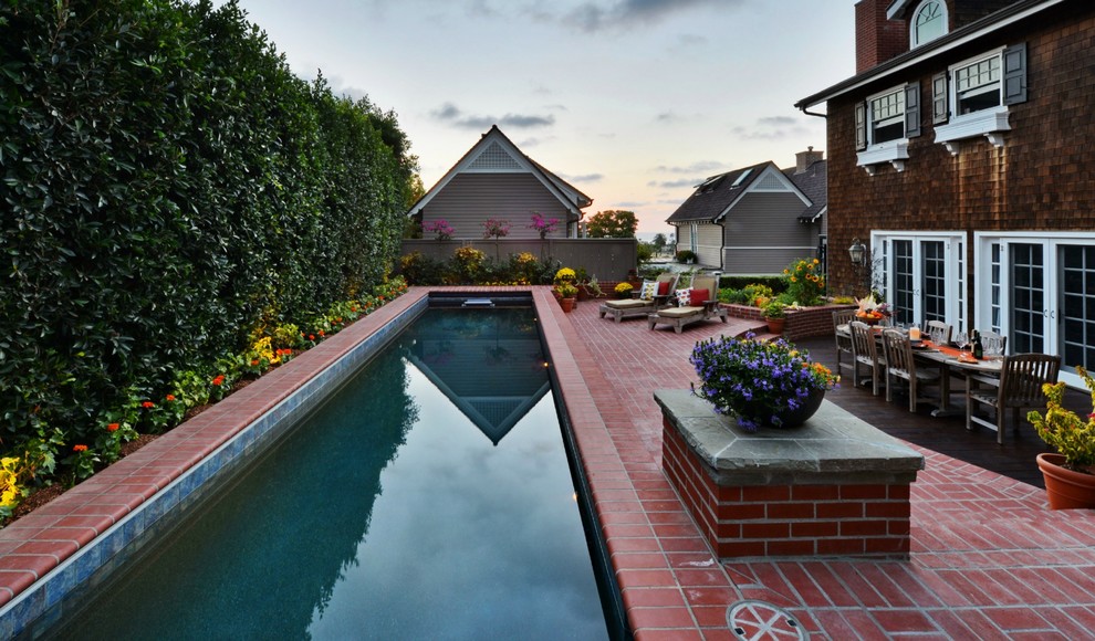 Foto de piscina alargada costera de tamaño medio rectangular en patio trasero con adoquines de ladrillo