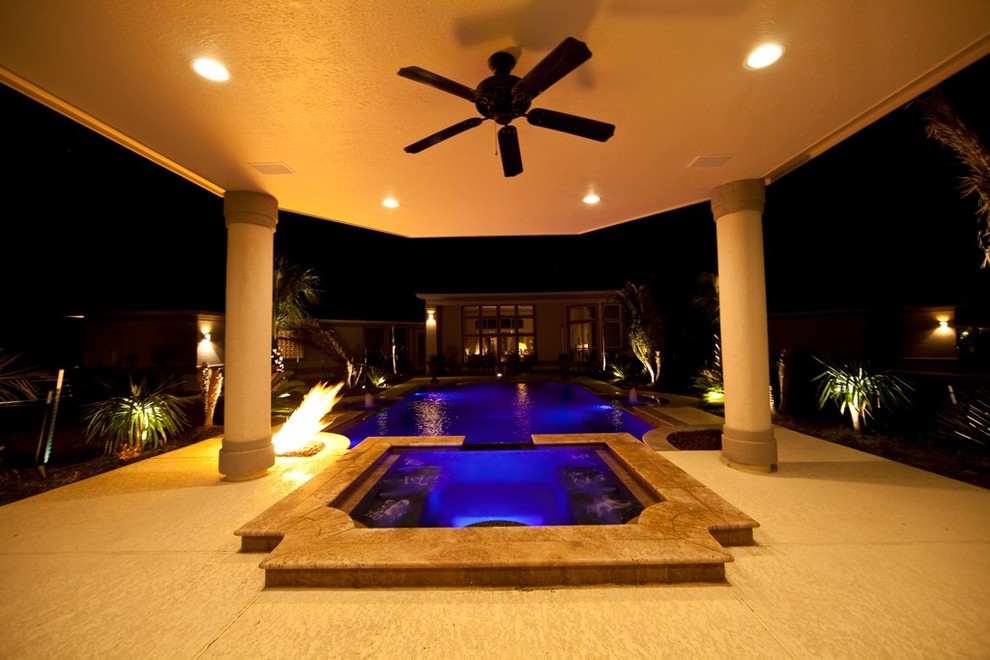 Ejemplo de casa de la piscina y piscina mediterránea a medida en patio trasero con losas de hormigón