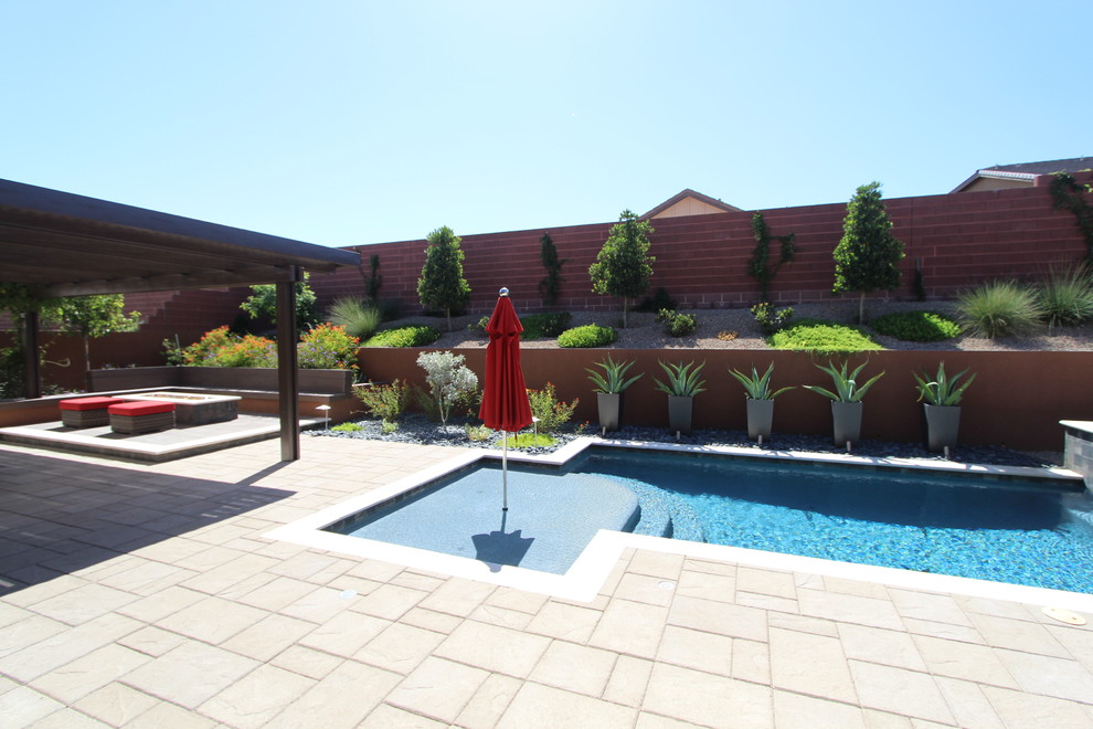 Пример оригинального дизайна: естественный, прямоугольный бассейн среднего размера на заднем дворе в современном стиле с покрытием из каменной брусчатки