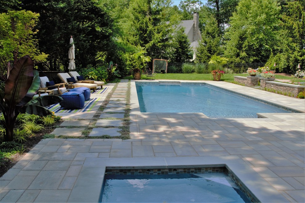 Inspiration för en stor funkis rektangulär pool på baksidan av huset, med spabad och naturstensplattor