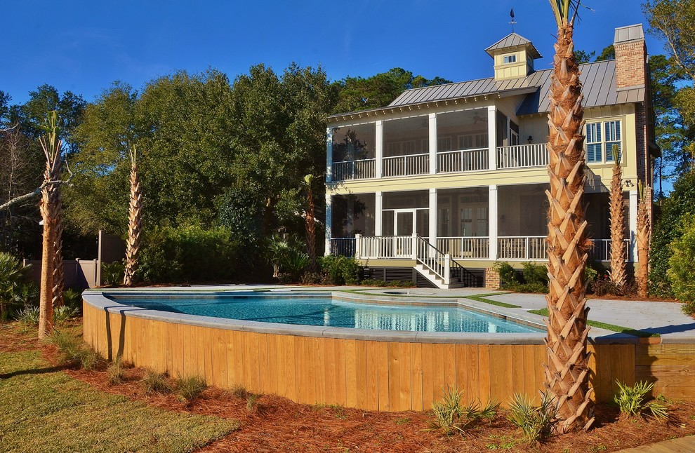 Ejemplo de piscina con fuente elevada costera de tamaño medio a medida en patio trasero con losas de hormigón