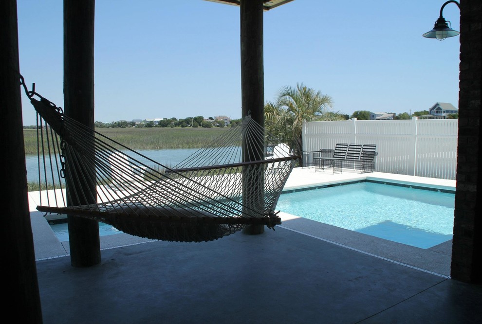 Esempio di una piscina monocorsia stile marinaro a "L" di medie dimensioni e dietro casa con pavimentazioni in cemento