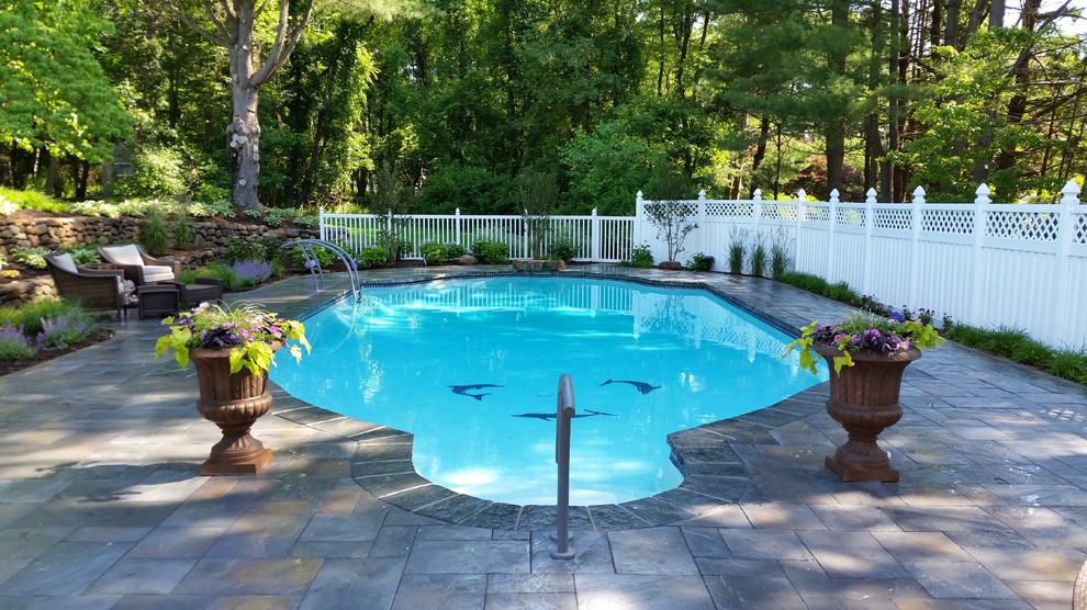 Ejemplo de piscina con fuente minimalista grande rectangular en patio trasero con adoquines de piedra natural