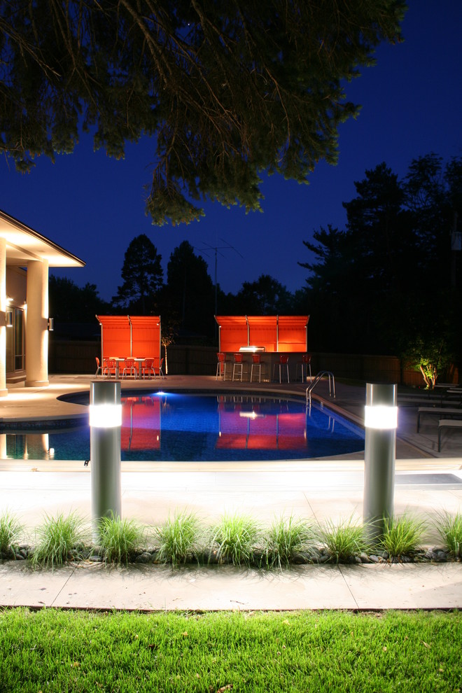 Inspiration for a medium sized contemporary back kidney-shaped lengths swimming pool in Kansas City with stamped concrete.