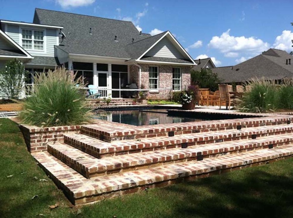 Imagen de casa de la piscina y piscina alargada clásica grande a medida en patio trasero con adoquines de ladrillo