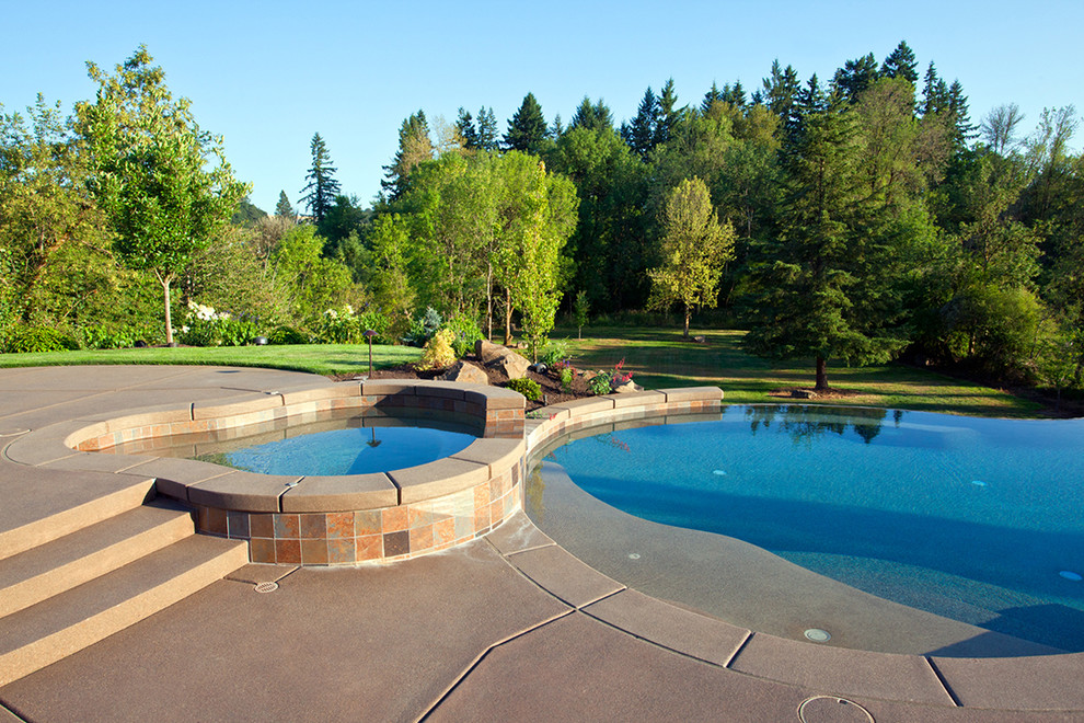 Esempio di una piscina design personalizzata con lastre di cemento