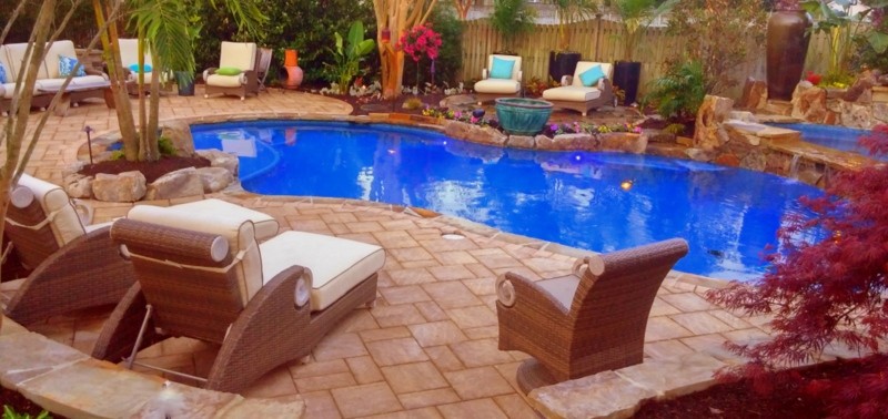 Foto di una grande piscina coperta tropicale personalizzata con fontane e pavimentazioni in pietra naturale