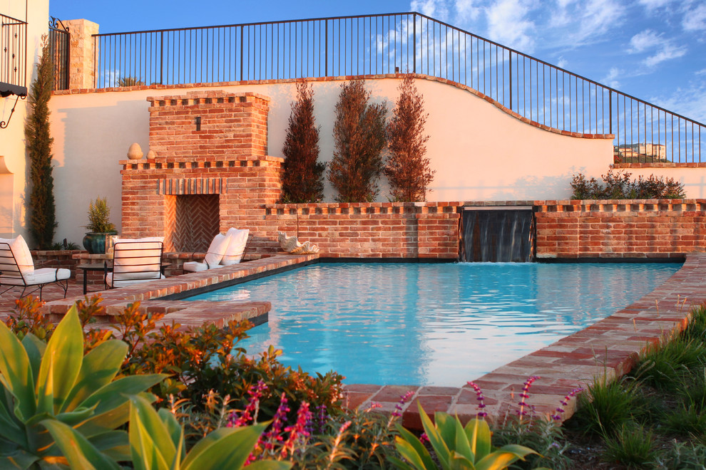 Immagine di una piscina tradizionale rettangolare con pavimentazioni in mattoni e fontane
