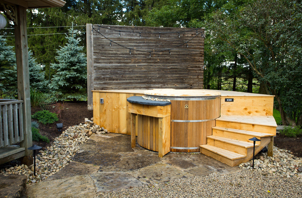 Exemple d'une petite piscine arrière nature ronde avec un bain bouillonnant et une terrasse en bois.