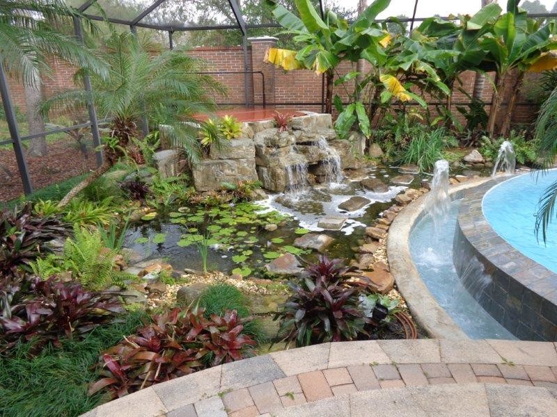 Großer Pool in individueller Form mit Wasserspiel und Pflastersteinen in Tampa