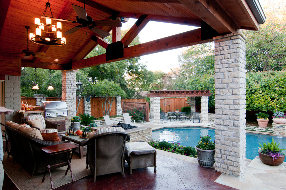 Photo of a large modern back custom shaped lengths swimming pool in Dallas with a water feature and concrete slabs.