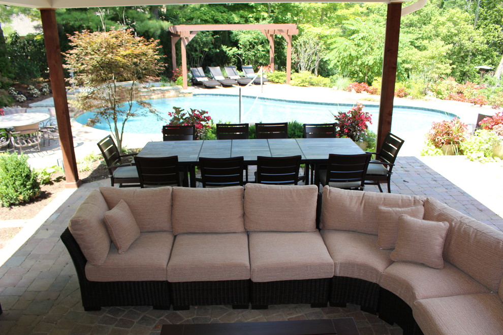 Diseño de piscina con fuente natural tradicional renovada de tamaño medio a medida en patio trasero con adoquines de ladrillo