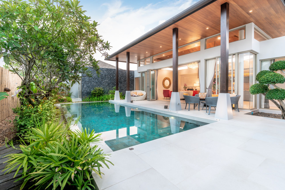 Стильный дизайн: прямоугольный бассейн на заднем дворе в современном стиле с покрытием из бетонных плит - последний тренд