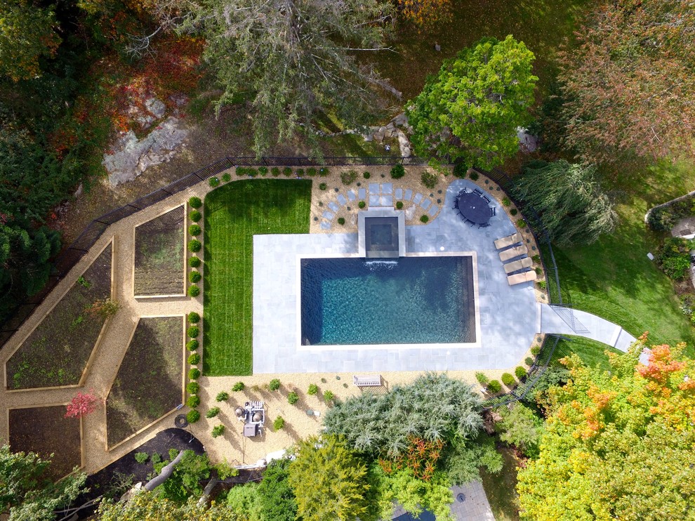Foto de piscinas y jacuzzis alargados actuales grandes rectangulares en patio trasero con adoquines de piedra natural