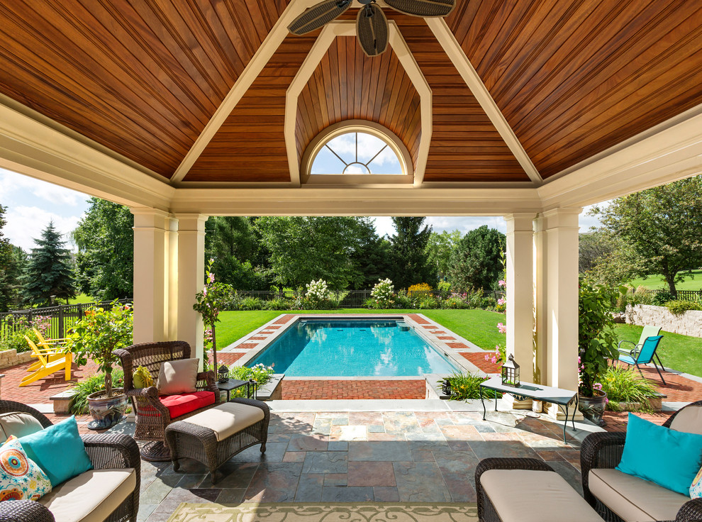 Modelo de casa de la piscina y piscina contemporánea grande rectangular en patio trasero con adoquines de ladrillo