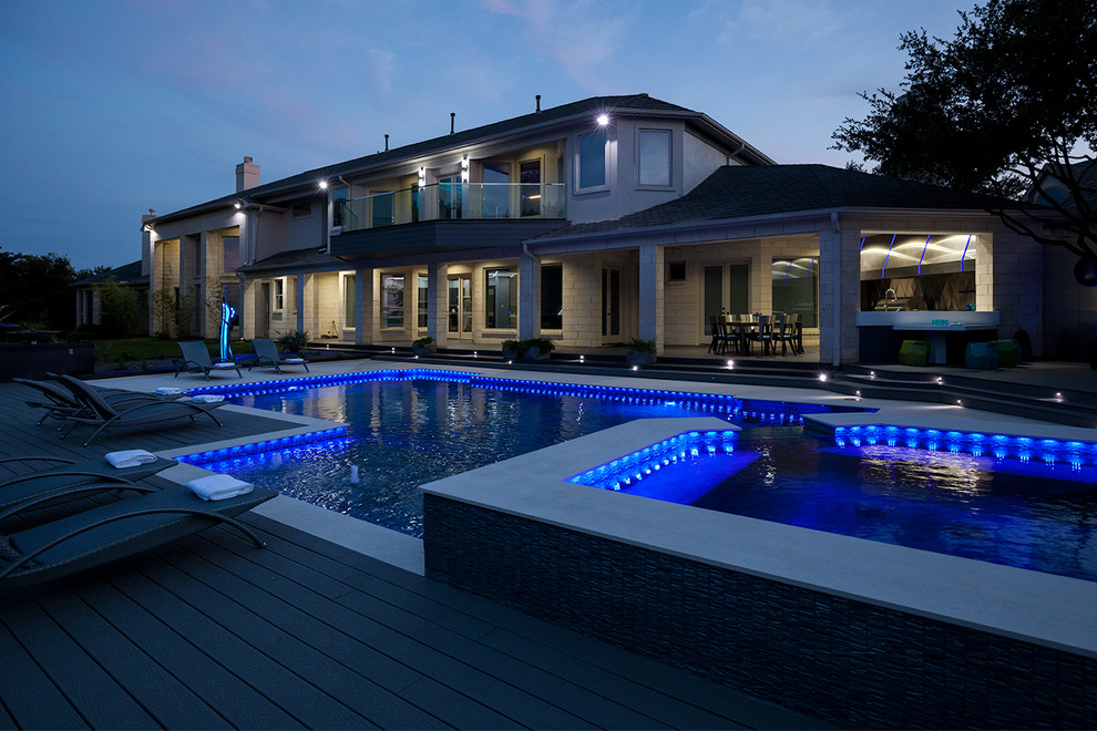 Foto de piscinas y jacuzzis alargados actuales grandes rectangulares en patio trasero con losas de hormigón