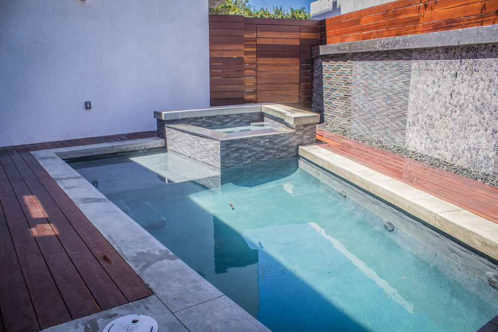 Cette image montre un petit couloir de nage arrière minimaliste sur mesure avec un bain bouillonnant et une terrasse en bois.
