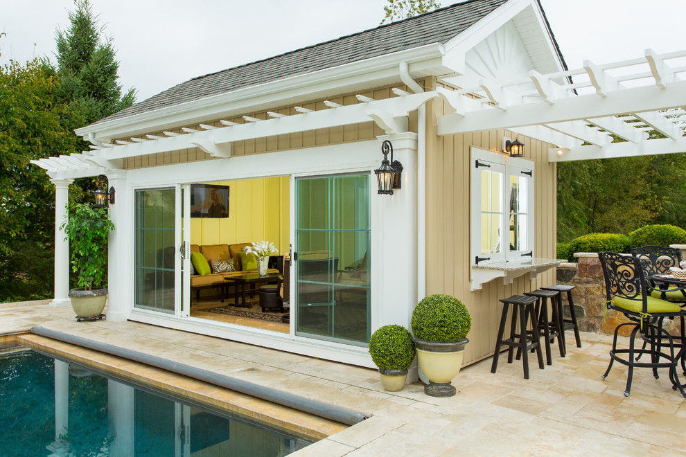 Foto de casa de la piscina y piscina clásica rectangular en patio trasero con suelo de baldosas