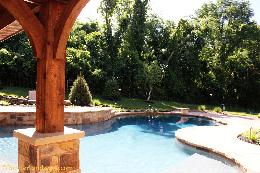 Immagine di una grande piscina naturale classica personalizzata dietro casa con una dépendance a bordo piscina e cemento stampato