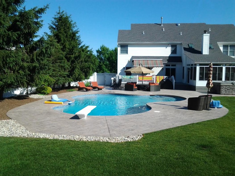 Inspiration för en mellanstor vintage rektangulär pool på baksidan av huset, med stämplad betong