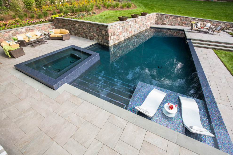 Esempio di una grande piscina fuori terra minimal a "L" dietro casa con piastrelle