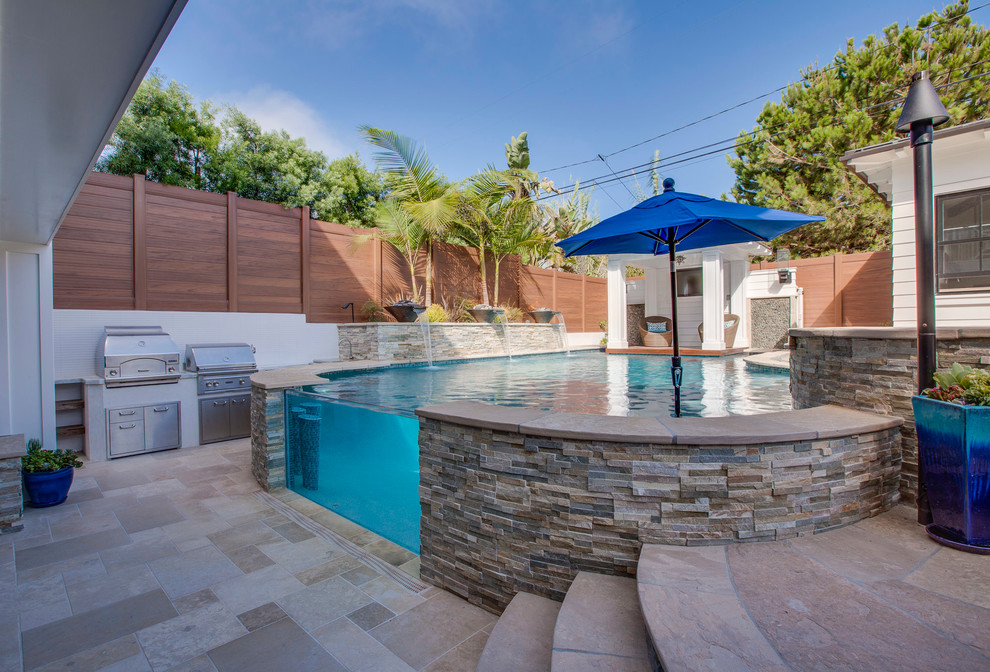 Inspiration for a large timeless backyard stone and custom-shaped infinity pool fountain remodel in Los Angeles