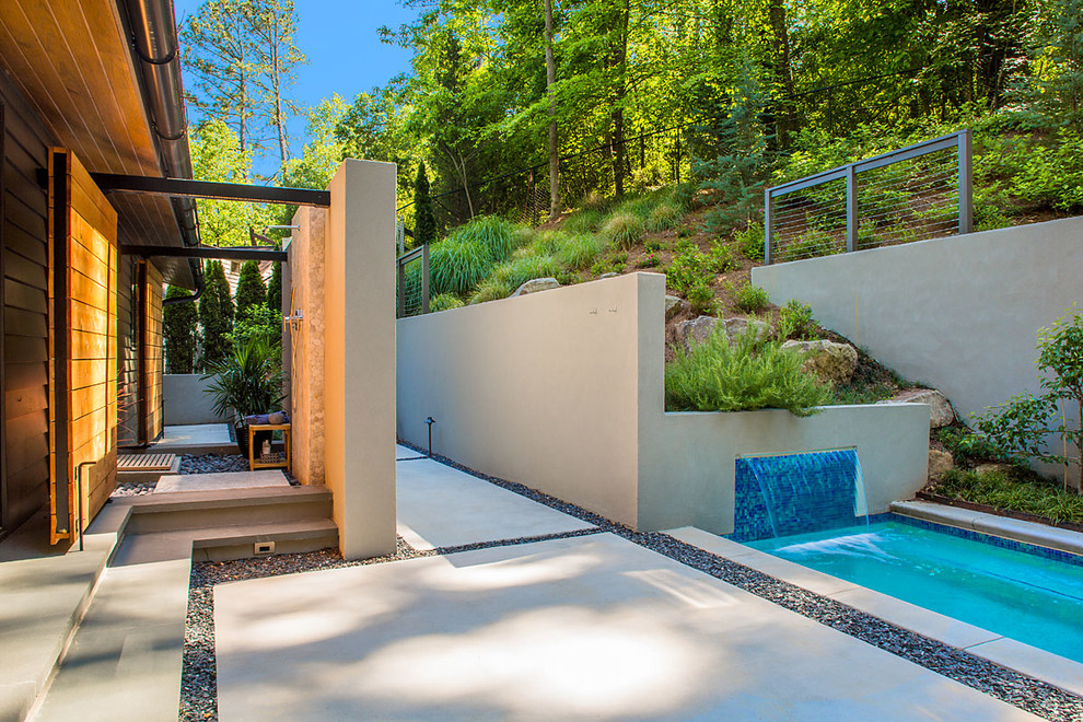 Ispirazione per una piscina naturale minimal rettangolare di medie dimensioni e in cortile con una vasca idromassaggio e lastre di cemento