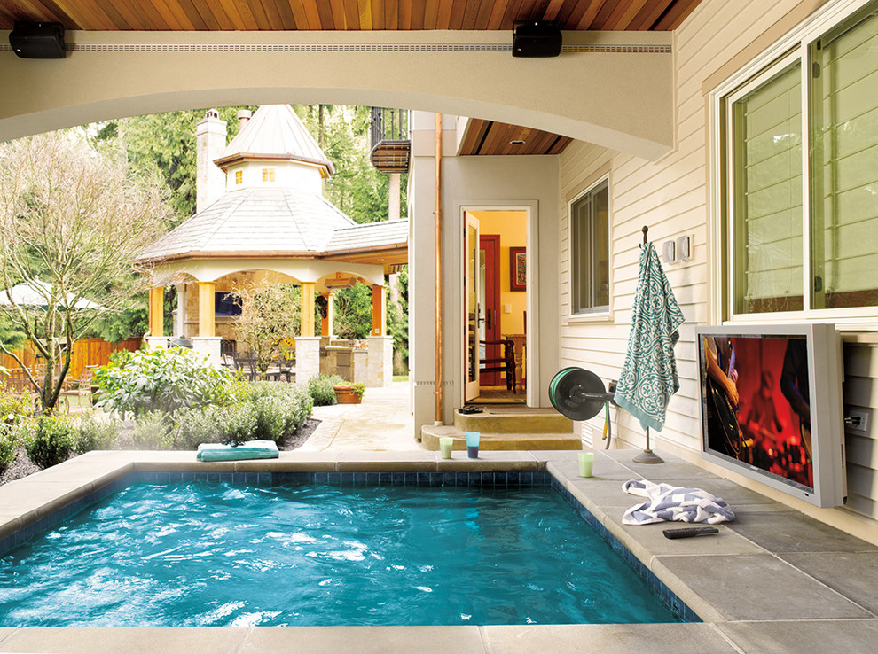 Modelo de piscinas y jacuzzis de estilo americano extra grandes rectangulares en patio trasero con adoquines de hormigón