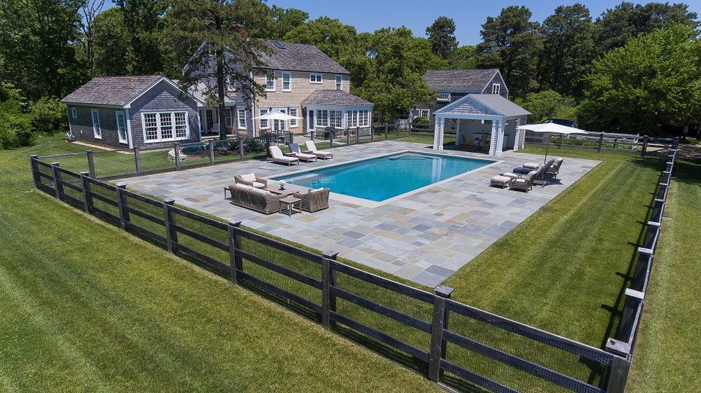 Стильный дизайн: большой спортивный, прямоугольный бассейн на заднем дворе в стиле кантри с покрытием из каменной брусчатки - последний тренд