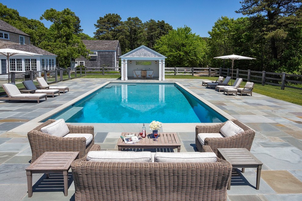 This is an example of a large traditional back rectangular lengths swimming pool in Boston with concrete paving and fencing.