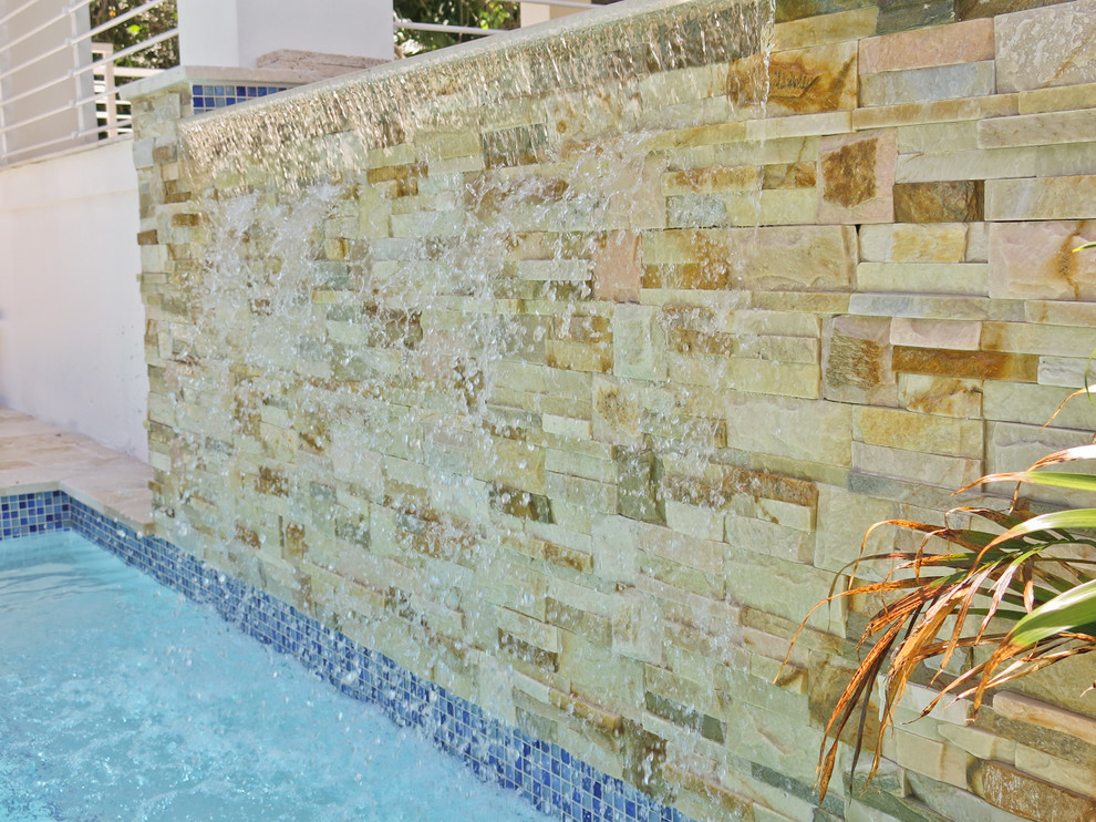 Foto di una piscina naturale minimal rettangolare dietro casa con fontane e pavimentazioni in pietra naturale