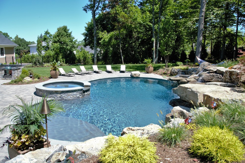 Imagen de piscinas y jacuzzis alargados tropicales grandes tipo riñón en patio trasero con adoquines de piedra natural