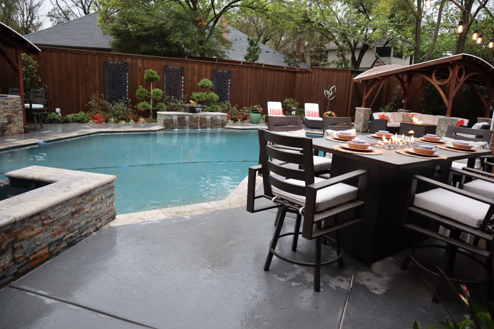 Expansive contemporary back custom shaped lengths hot tub in Dallas with concrete slabs.