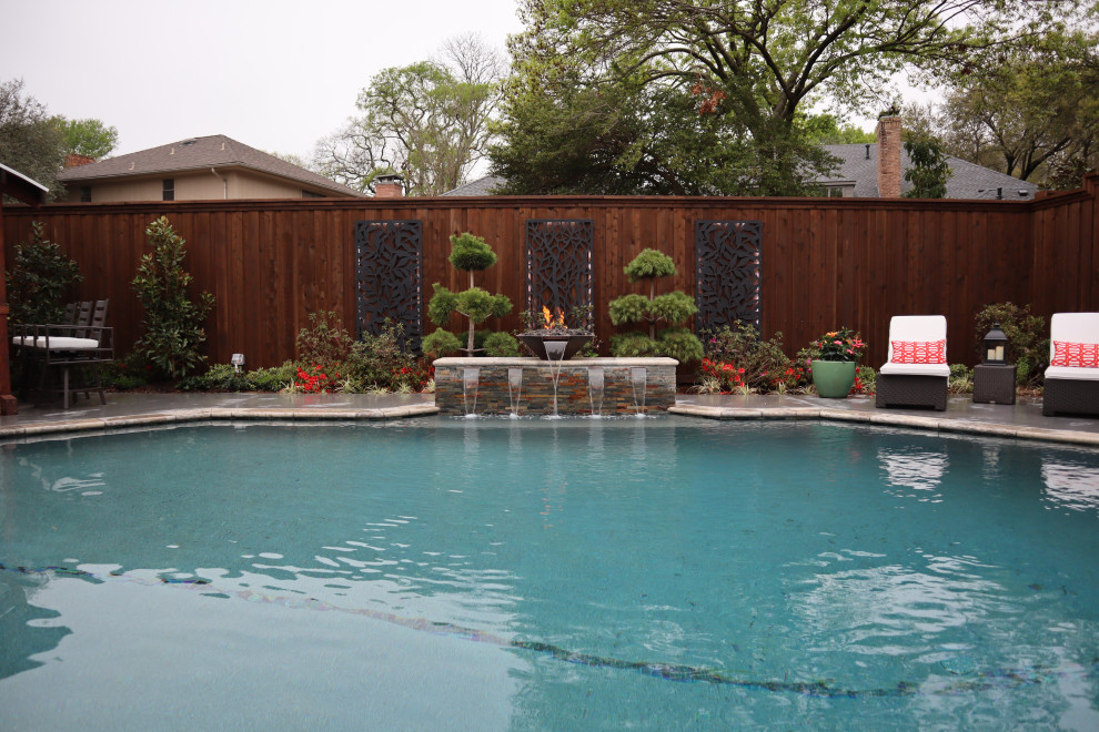 Esempio di un'ampia piscina monocorsia design personalizzata dietro casa con una vasca idromassaggio e lastre di cemento